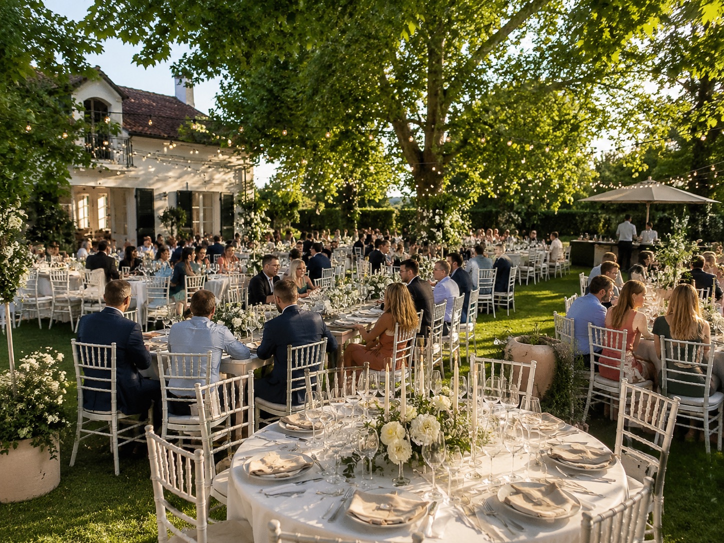 Gartenhochzeit mit gedeckten Tischen und Lichterketten